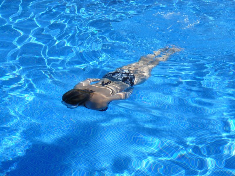 Person bathing in an open swimming pool